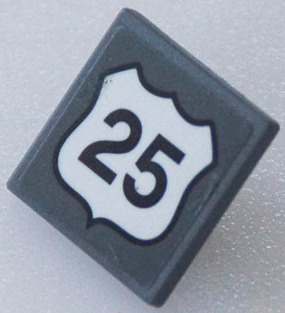 LEGO 2x2 dark gray tile with a white US Route 25 shield sticker.