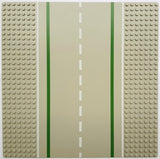 LEGO 32x32 straight road baseplate with green lines, white dashed center, and studded light tan shoulders.