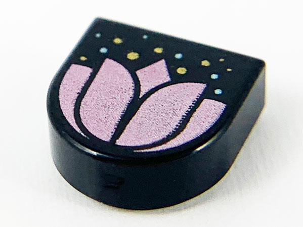 Black LEGO 24246pb003 tile with metallic pink flower, gold & metallic light blue dots pattern on white background.