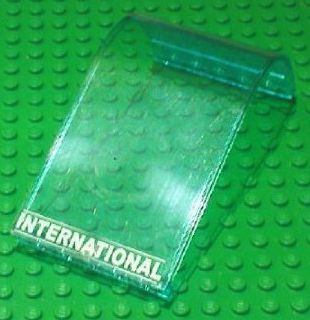 Transparent teal curved top LEGO panel with white 'INTERNATIONAL' text.