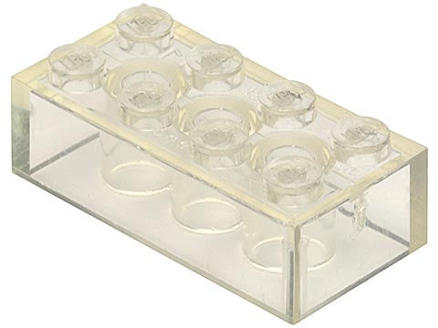 Close-up of a transparent clear LEGO 2x4 brick without cross supports, showing 8 round studs on top.