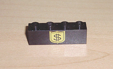 Close-up of a black LEGO 1x4 brick, model 3010pb017, with a yellow shield pattern featuring a dollar sign on a wooden surface.