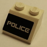 White LEGO 2x2 slope brick with a black background pattern featuring the word 'POLICE' in white text.