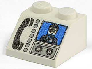 White LEGO 45 2x2 slope brick with a printed black phone, light gray buttons, a minifigure on a blue screen, and tape reels graphic.