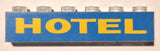 LEGO 3067pb10 blue 1x6 brick with yellow 'HOTEL' print and clear studs.