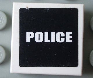 White LEGO 2x2 tile with a black background 'POLICE' sticker in white capital letters.