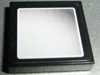 Black LEGO 2x2 tile with a white and black dotted pattern resembling a vehicle mirror, featuring rounded corners and a small border.