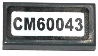 Dark grey LEGO 1x2 tile with a white sticker featuring black text 'CM60043', part of Set 60043.