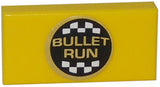 Yellow LEGO 1x2 tile with a centered black circular sticker displaying 'BULLET RUN' in gold text and a checkered border.