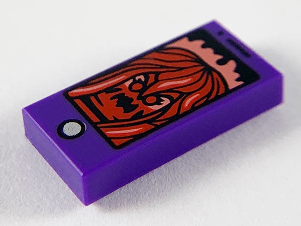 Purple LEGO 1x2 tile with smartphone print displaying a dark red ghost or creature with wavy hair.