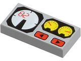 A light gray LEGO 1x2 tile with a printed pattern featuring a white gauge with red '82', two yellow gauges, and two red buttons.