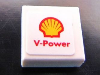 Close-up of a white LEGO 1x1 tile featuring the red and yellow Shell logo and 'V-Power' text.