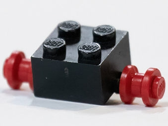 Black LEGO 2x2 modified brick with four studs on top, featuring two red wheels for dually tires attached to its sides.