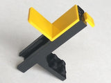 A black LEGO forklift vehicle base with a yellow V-shaped fork and a small yellow piece attached, standing on a white surface.