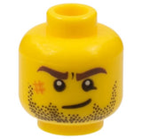 Yellow LEGO minifigure head with dark brown eyebrows, black beard stubble, dark orange scuff mark, and a lopsided grin.