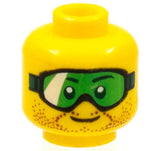 Yellow LEGO minifigure head with green goggles, brown stubble, and a small smile on a white background.