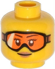 Yellow LEGO minifigure head, female, with orange goggles, medium nougat lips, and a small smile pattern.