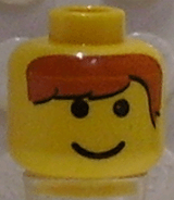 Yellow LEGO minifigure head with black eyes, smile, and printed brown hair bangs pattern.