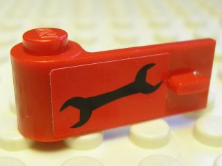Red LEGO Door 1 x 3 x 1 Left piece with a black wrench sticker (3822pb019), on a white LEGO baseplate.