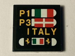 Black LEGO 2x2 tile with pit board pattern: P1, Italian flag; P3, Danish flag; 'ITALY'; and Ferrari logos.