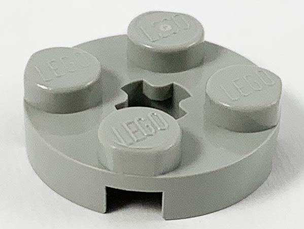 Light grey LEGO round 2x2 plate with four studs and a star-shaped axle hole in the center.