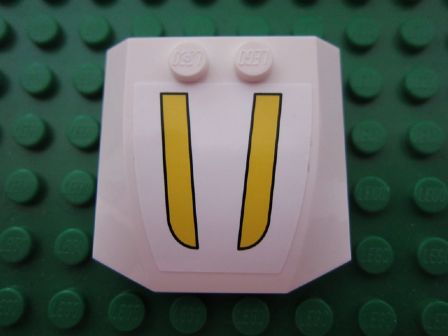 White LEGO 4x4x2/3 triple curved wedge part with a sticker showing two vertical yellow stripes, on a green studded baseplate.
