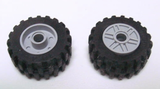 Two LEGO wheels, black tires 30.4 x 14 offset tread, grey hubs. One hub has a pin hole, the other fake bolts and shallow spokes.