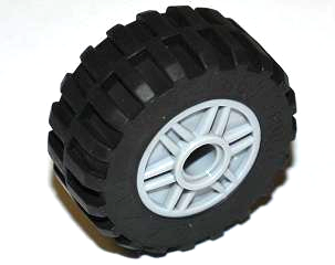 A single LEGO wheel with a light gray hub and a black tire, featuring an offset tread pattern with a central band.