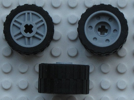 Three LEGO 55982c02 wheels, 18mm D. x 14mm, with 24x14 shallow tread tires, shown from different angles.
