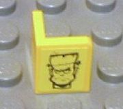 Yellow LEGO 1x1x1 corner panel with a black Frankenstein monster head pattern.