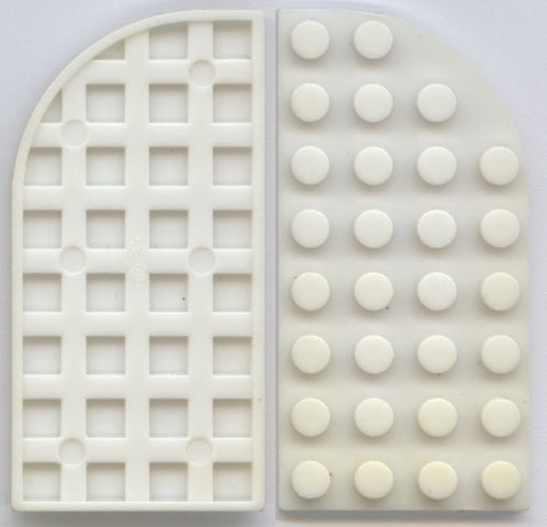 Two white LEGO curved 4x8 plates, one showing its waffle bottom, the other its stud top.
