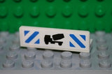 White LEGO 1x4x1 panel with black cement mixer and blue danger stripes pattern (sticker) on a gray baseplate.