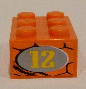 Orange LEGO 2x3 brick with six studs. One side features a gray oval with yellow '12' on a snakeskin pattern background.