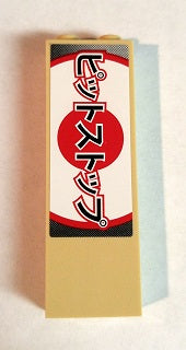 Beige LEGO brick 1x2x5 with a sticker featuring a red circle and black Japanese text 'ピットストップ' (Pit Stop) vertically.