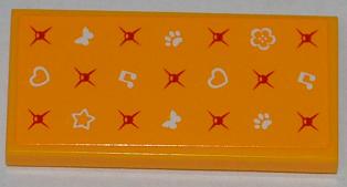 Orange LEGO 2x4 tile with white hearts, star, butterflies, music notes, paw prints, flower, and red asterisk patterns.