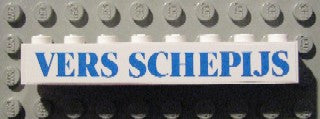 White LEGO 1x8 brick with blue 'VERS SCHEPIJS' text pattern, resting on a grey LEGO studded baseplate.