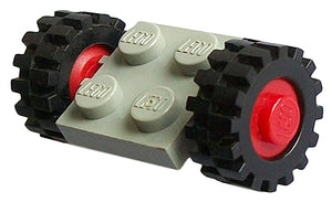 LEGO light grey 2x2 plate with two black wheels, red hubs, and offset tread tires on a white background.