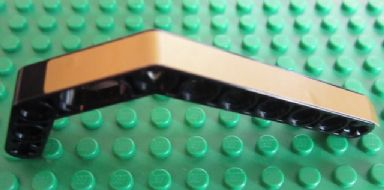 LEGO Technic bent liftarm, black with a gold stripe pattern, on a green LEGO baseplate.