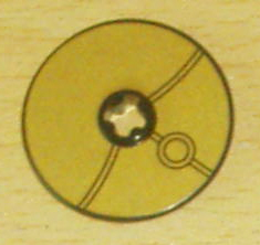 LEGO Technic Disk 3x3, gold with black lines pattern, a central stud, and a double-ring design.
