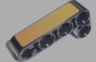 Black LEGO Technic modified bent L-shape 2x4 liftarm (32140pb04) with a gold panel sticker.