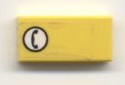 Yellow LEGO 1x2 tile with a white circle containing a black telephone icon on the left side, facing right.
