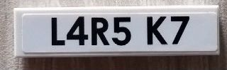 White LEGO 1x4 tile with black text 'L4R5 K7' printed on it.