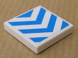 White LEGO 2x2 tile with blue chevron stripes on a white background.