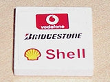 White LEGO 2x2 tile with Vodafone, Bridgestone, and Shell logos pattern, from sets 8362 and 8375.