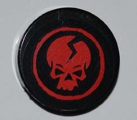 Round black LEGO 2x2 tile with a Ninjago red cracked skull in a red circle.