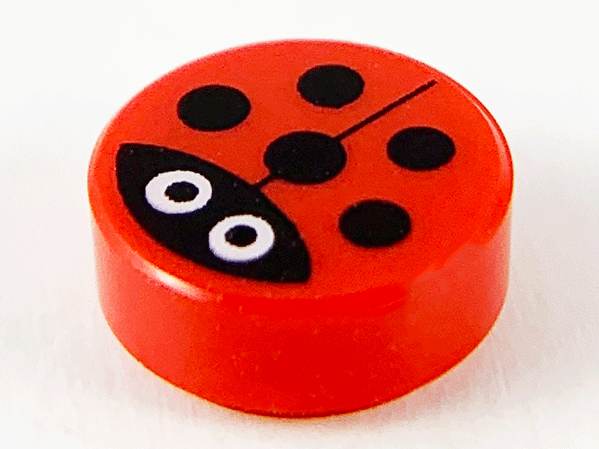 Red round 1x1 tile with a ladybug pattern. It has a black head, large white eyes with black pupils, a dividing line, and black spots.
